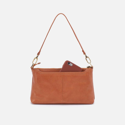 Brown leather handbag with a phone inside on a white background