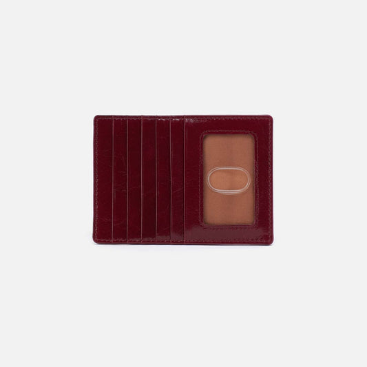 Red leather cardholder with a clear plastic window on a white background