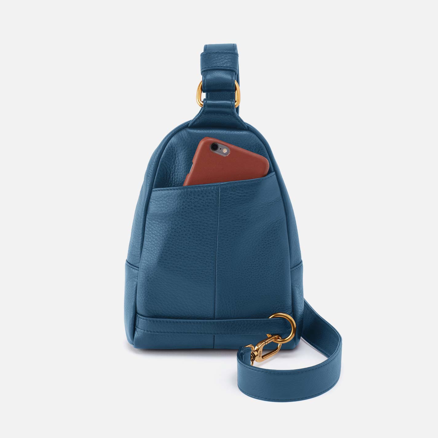 Blue leather sling bag with a brown phone case on a light gray background