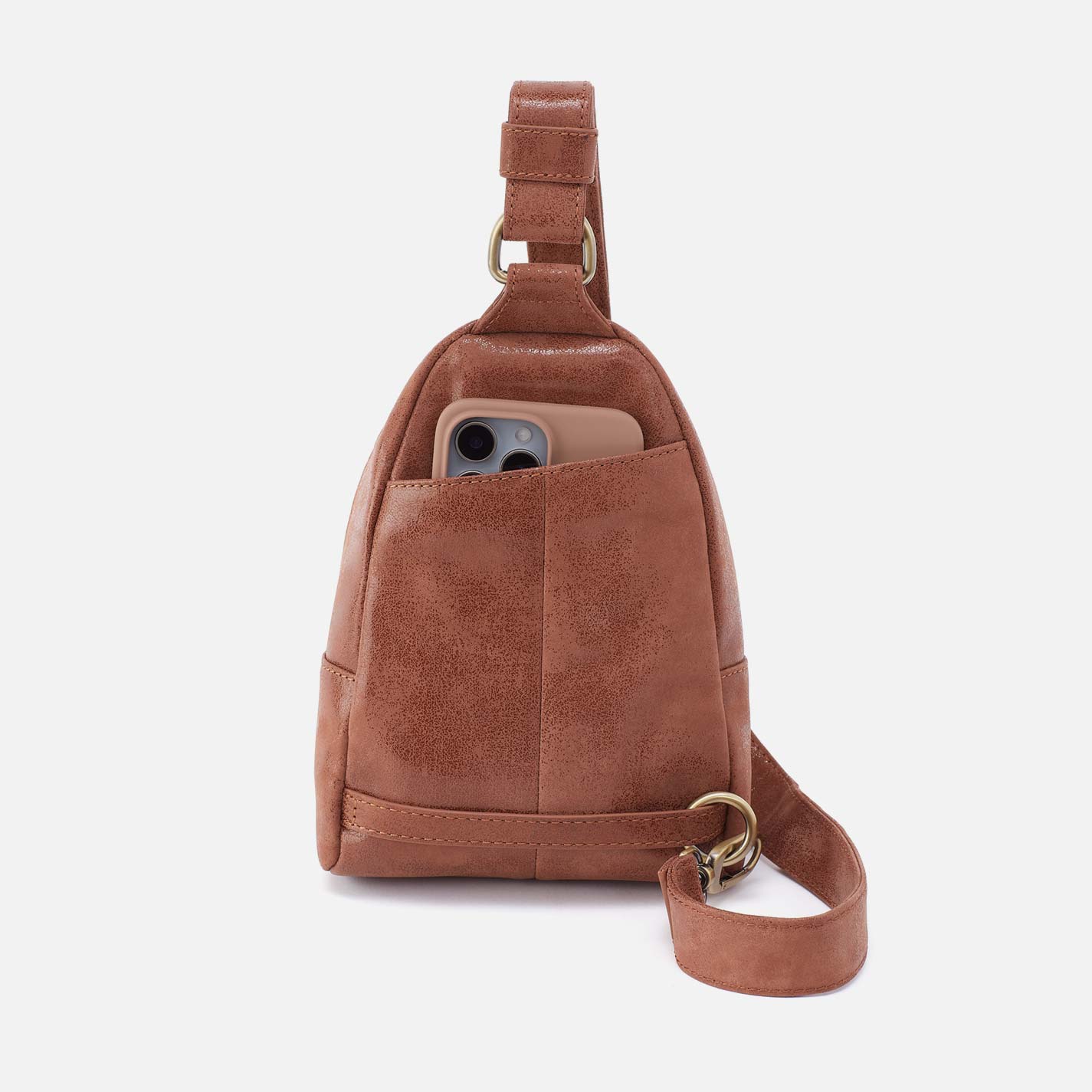 Brown leather sling bag with a phone in a pocket on a white background