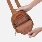 Hobo Fern Sling in warm honey leather with adjustable strap and zip closure.