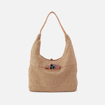 Beige woven handbag with a brown leather pocket on a white background