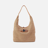 Beige woven handbag with a brown leather pocket on a white background