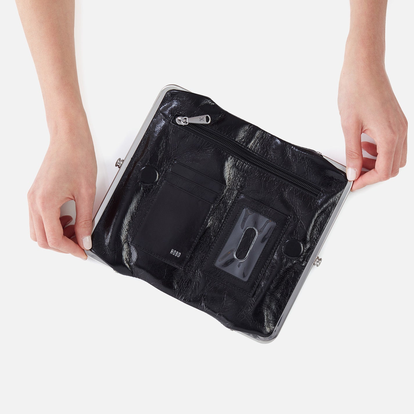 Black clutch bag held by a person on a white background