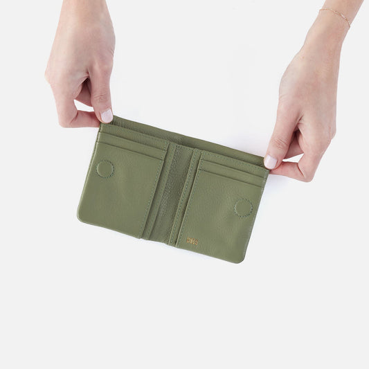Green wallet held open by hands on a white background