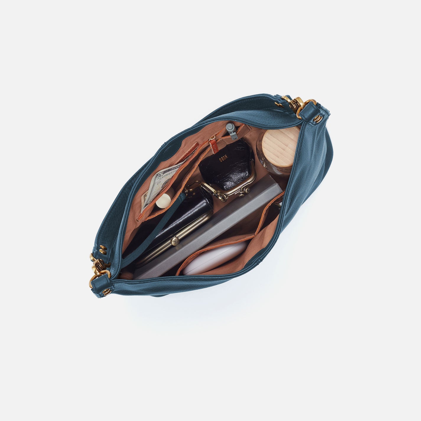 Open blue handbag with makeup items on a white background