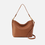 Brown leather handbag with a shoulder strap on a white background