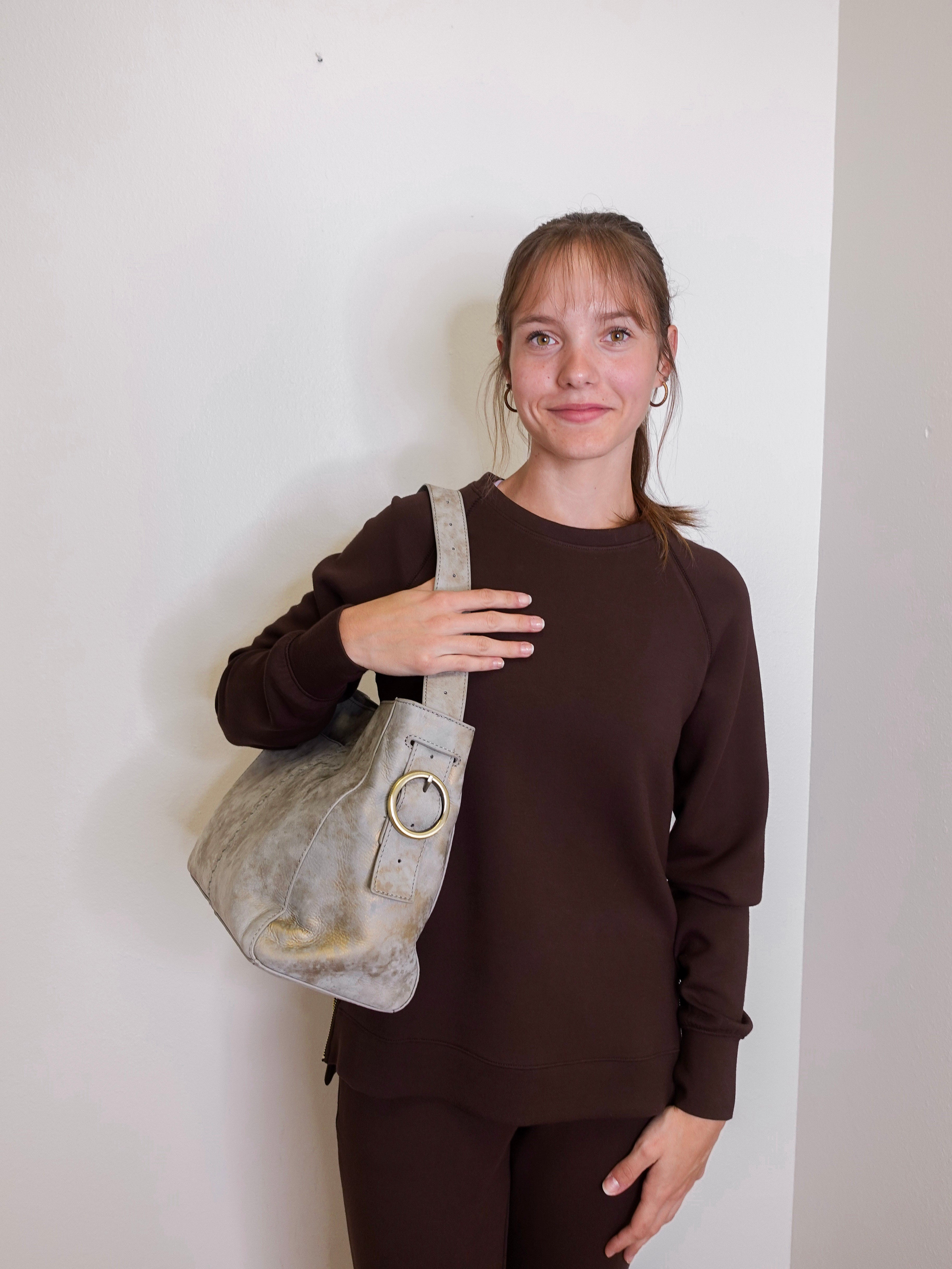 woman wearing the hobo bag render shoulder bag against a white wall.
