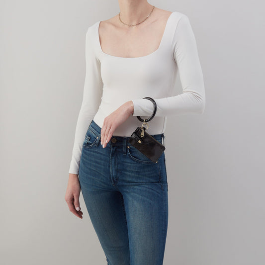 Person wearing a white long-sleeve top and blue jeans against a plain background