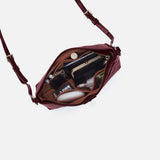 Maroon handbag with gold accents on a white background