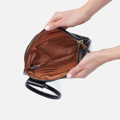 Hand holding an open black leather handbag with a white background