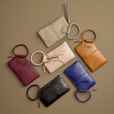 Collection of various leather handbags with ring handles on a brown background