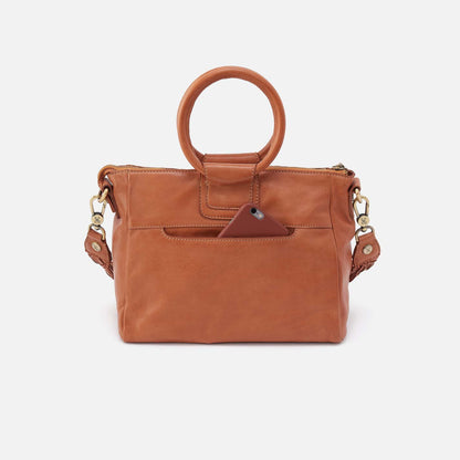 Brown leather handbag with gold accents on a white background