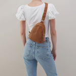 Hobo Fern Sling in warm honey leather with adjustable strap and zip closure.