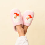 Pink slippers with Santa Claus design on a beige background