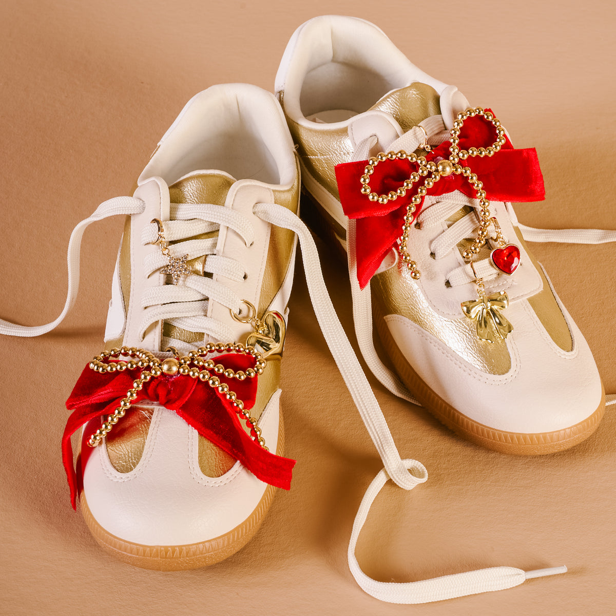 Decorative white sneakers with red bows and gold accents on a beige background