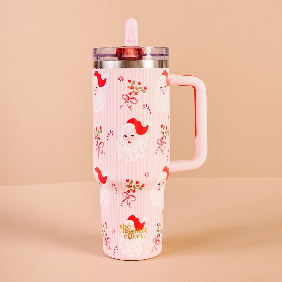 Pink tumbler with red bird design on a beige background