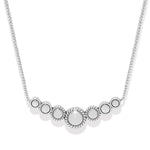 Silver necklace with circular pendants on a white background