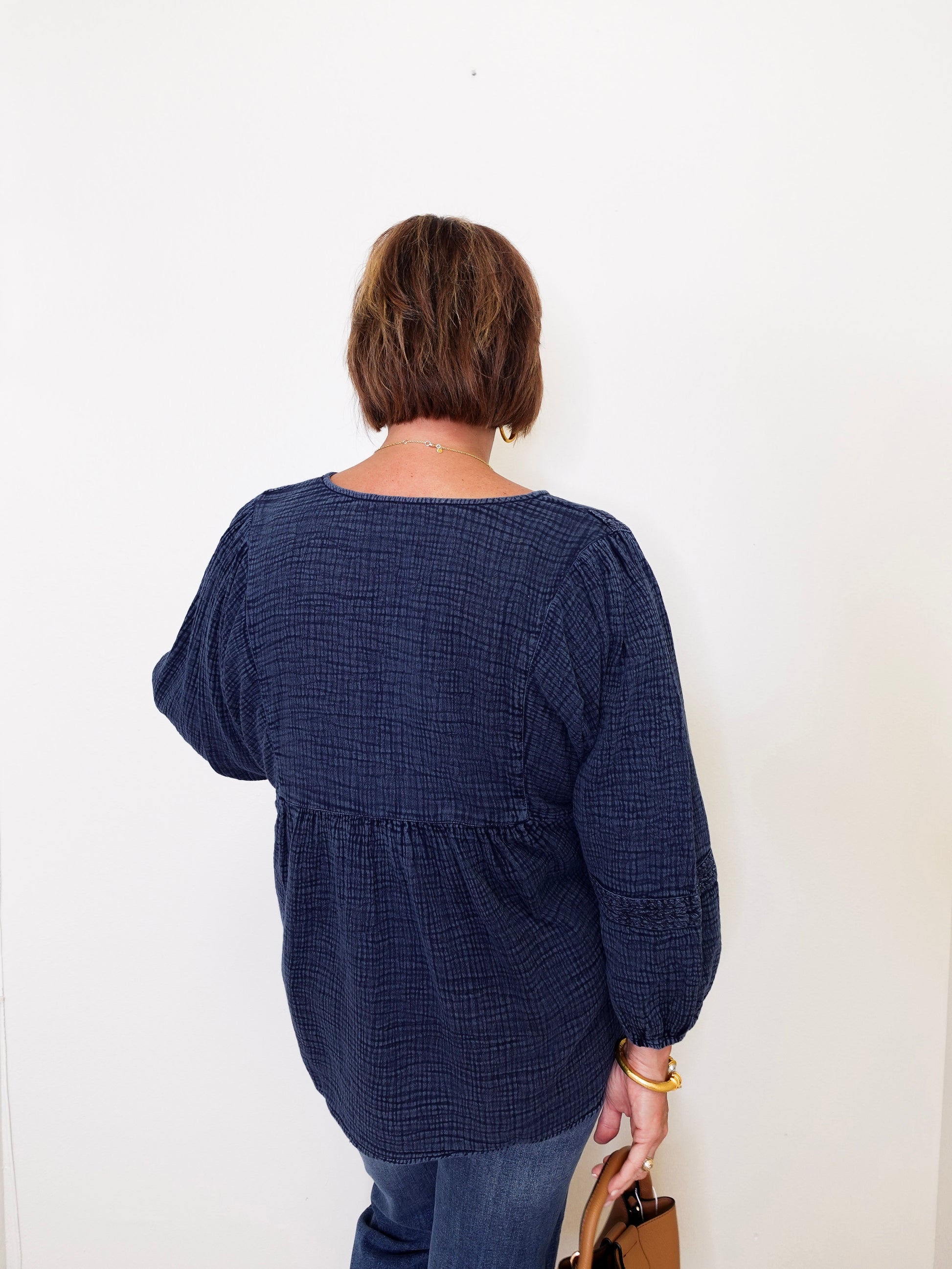 Person wearing a navy blue textured dress against a white background