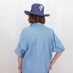 Person wearing a blue shirt and hat with a white background