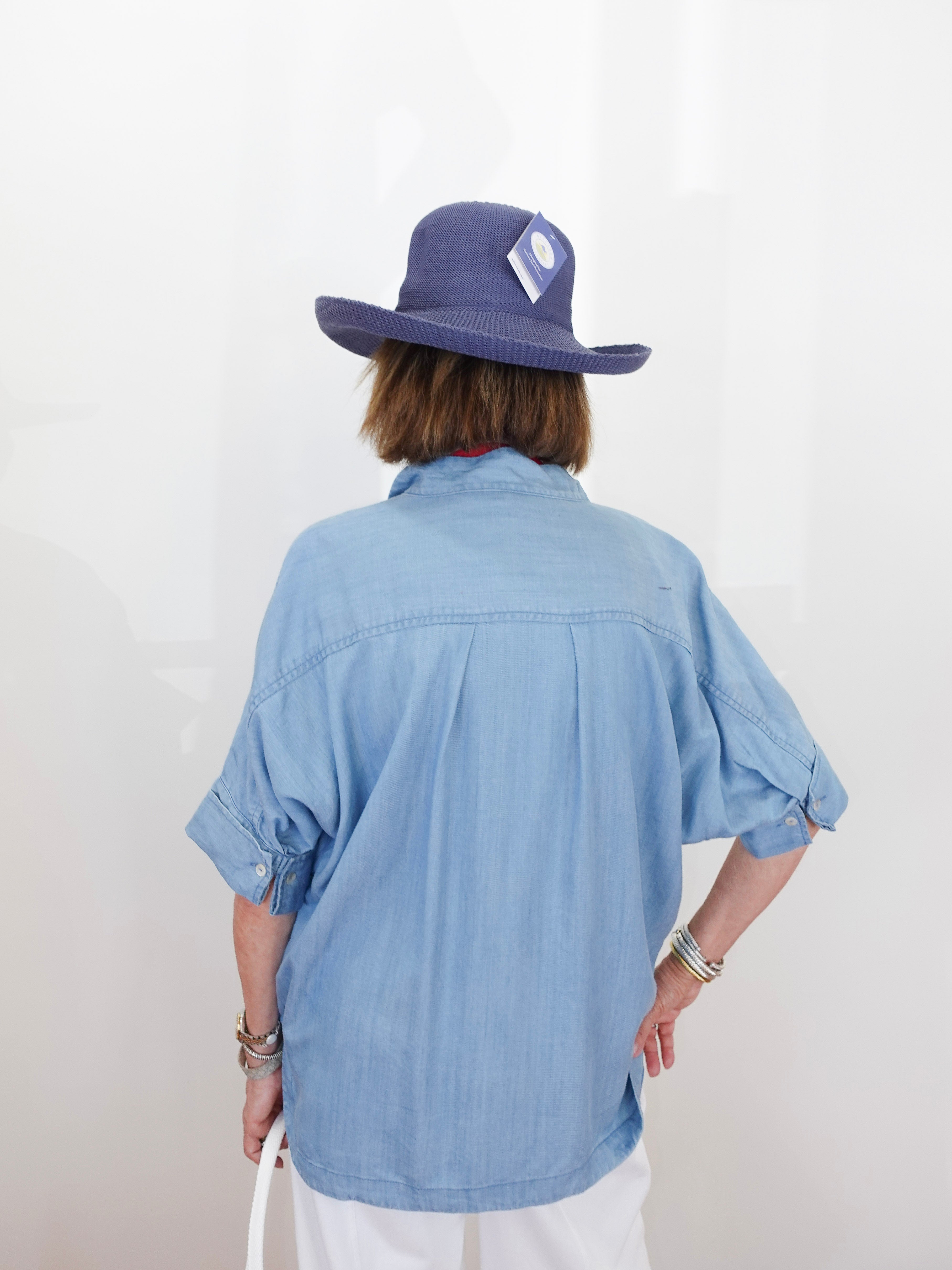 Person wearing a blue shirt and hat with a white background