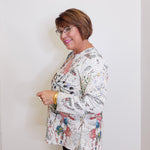 Woman wearing a patterned top against a white background