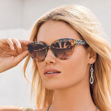 Woman wearing tortoiseshell sunglasses with a blurred background