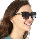 Woman wearing sunglasses with a decorative band, smiling.