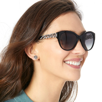 Woman wearing sunglasses with a decorative band, smiling.