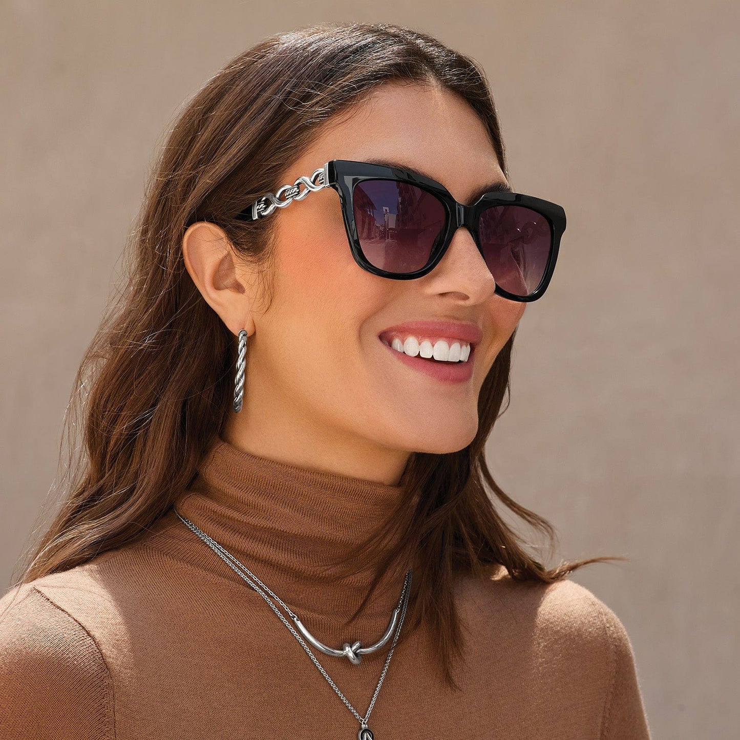 Woman wearing sunglasses with a neutral background