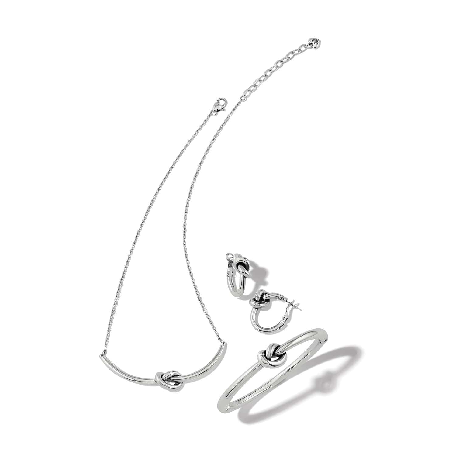 Silver necklace, bracelet, and ring set on a white background
