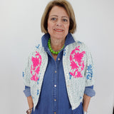 Woman wearing a blue outfit with a floral patterned cardigan against a white background