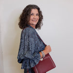 Woman holding a red handbag against a white background