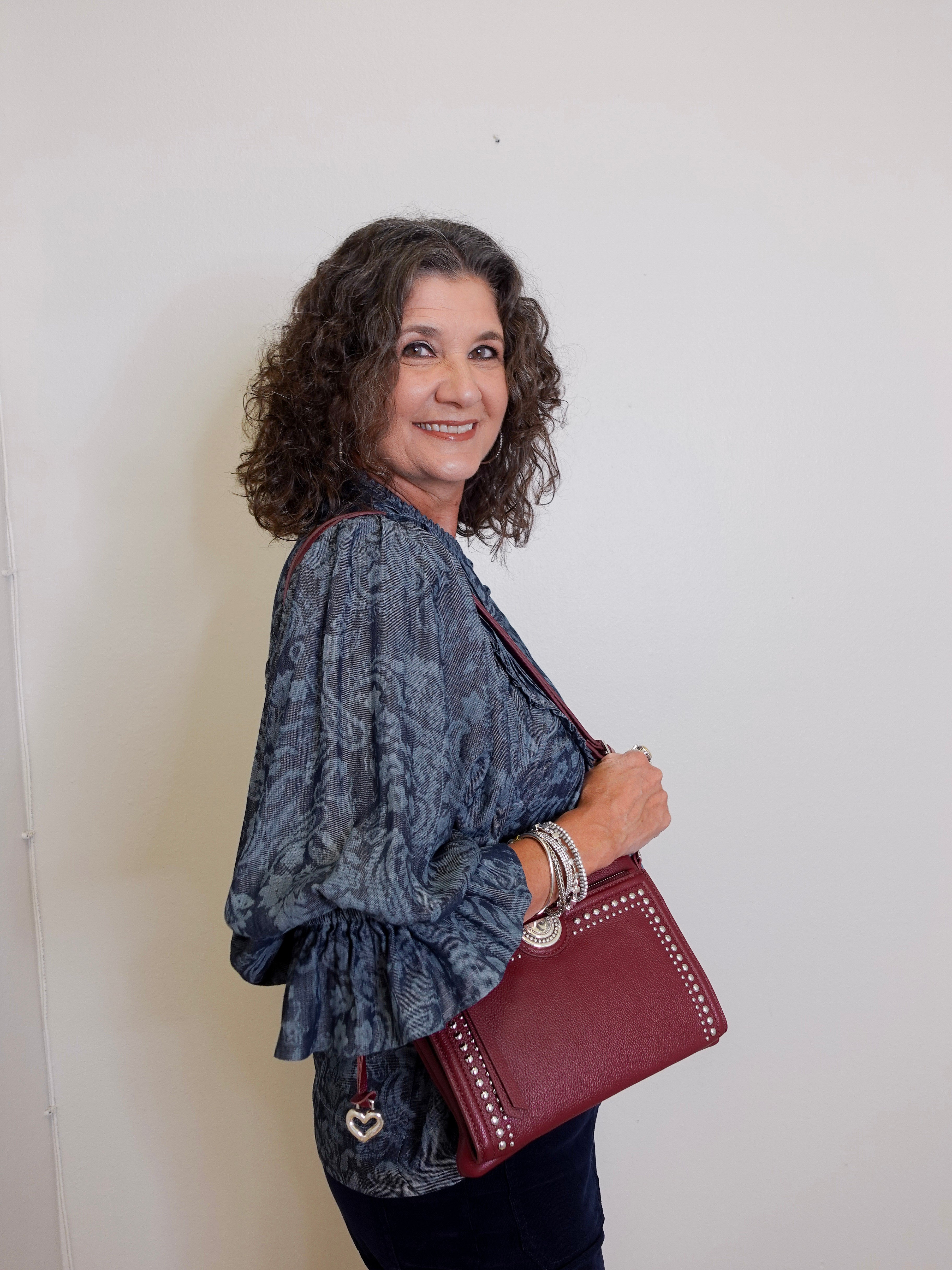 Woman holding a red handbag against a white background
