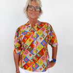 Person wearing a colorful patterned shirt with a white background