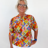Person wearing a colorful patterned shirt with a white background