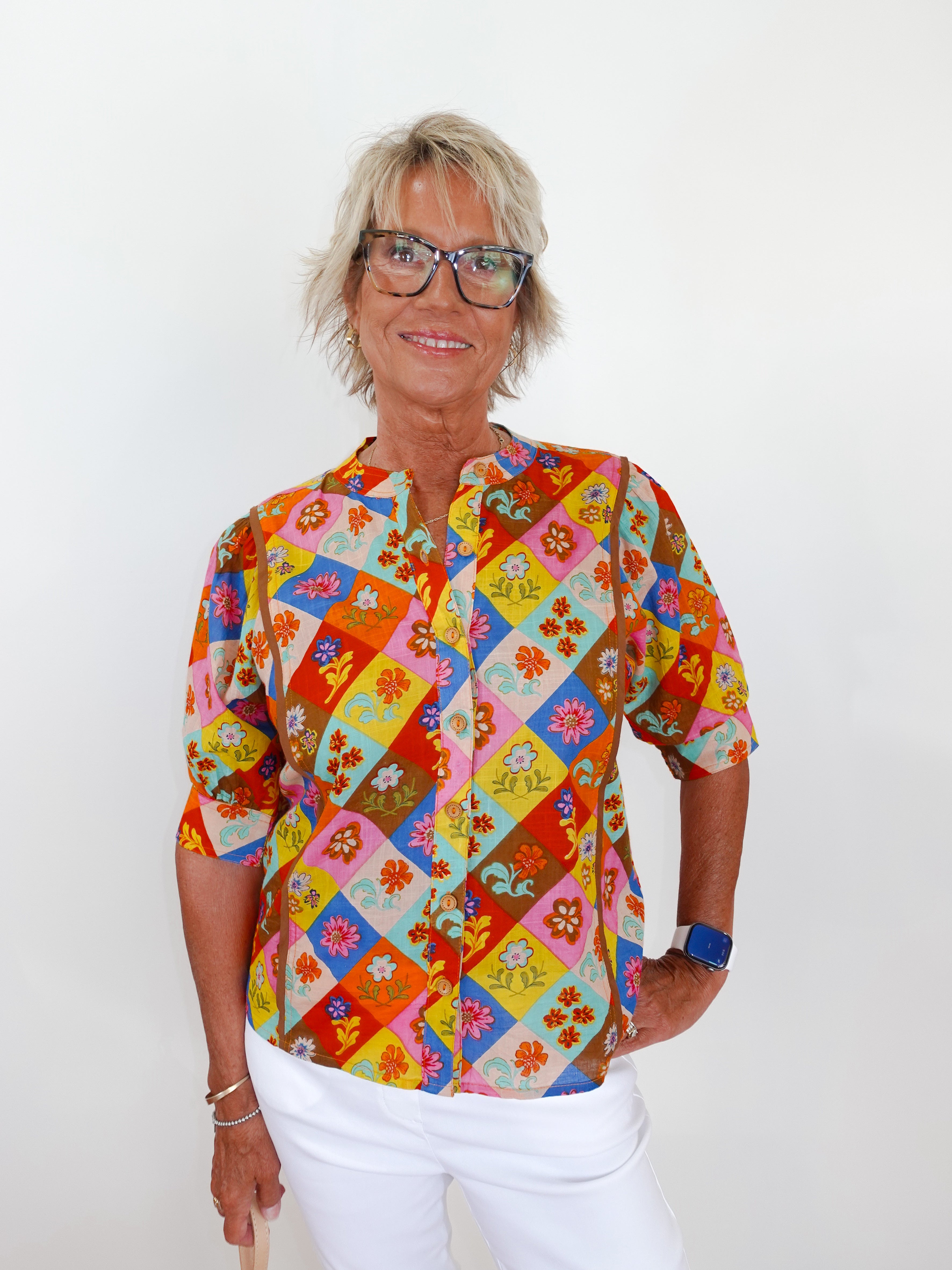 Person wearing a colorful patterned shirt with a white background