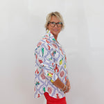 Person wearing a colorful patterned shirt and red pants against a white background