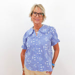Woman wearing a blue checkered blouse with a white background