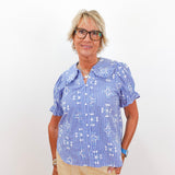 Woman wearing a blue checkered blouse with a white background