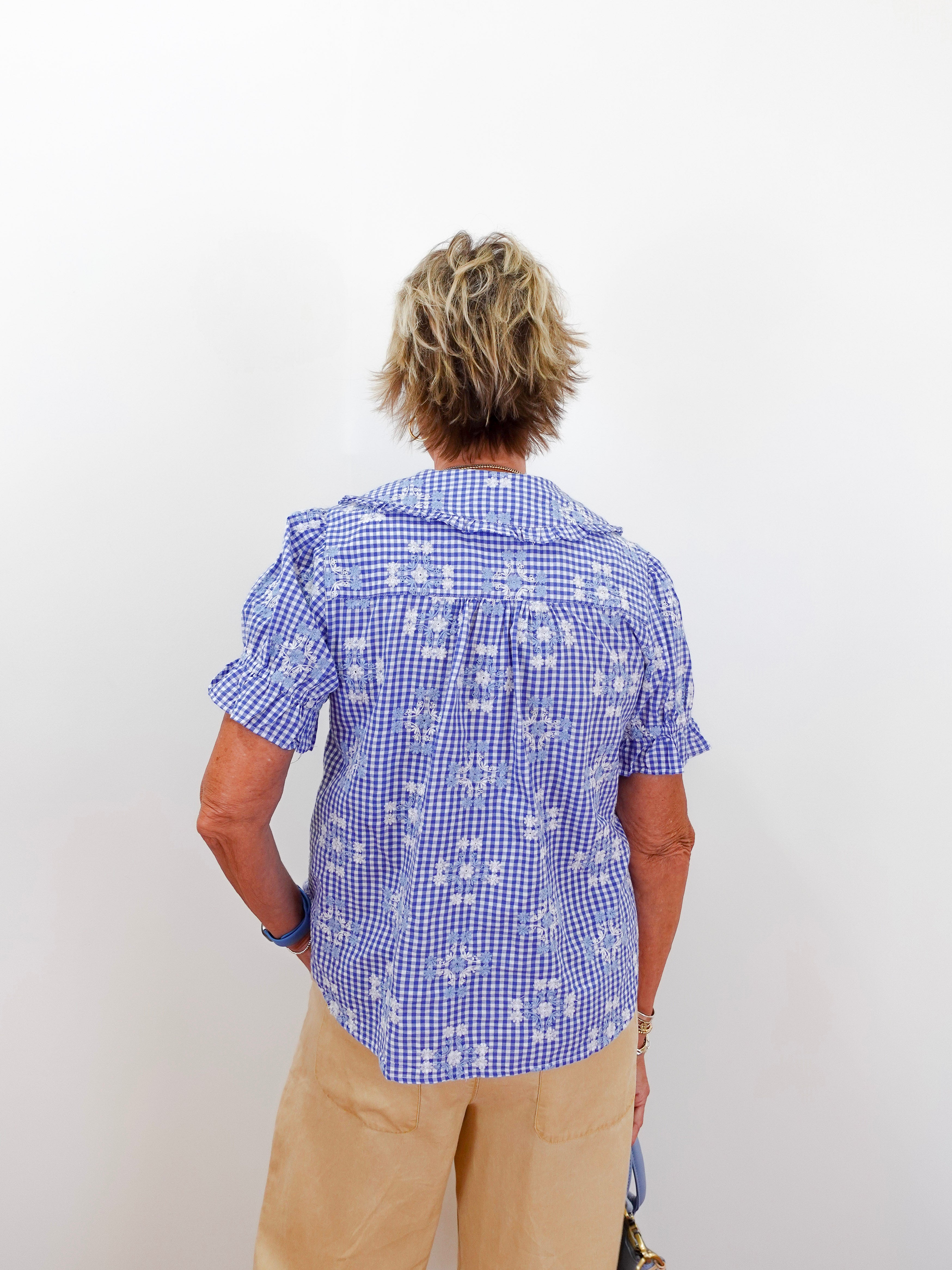 Person wearing a blue checkered shirt with a white background