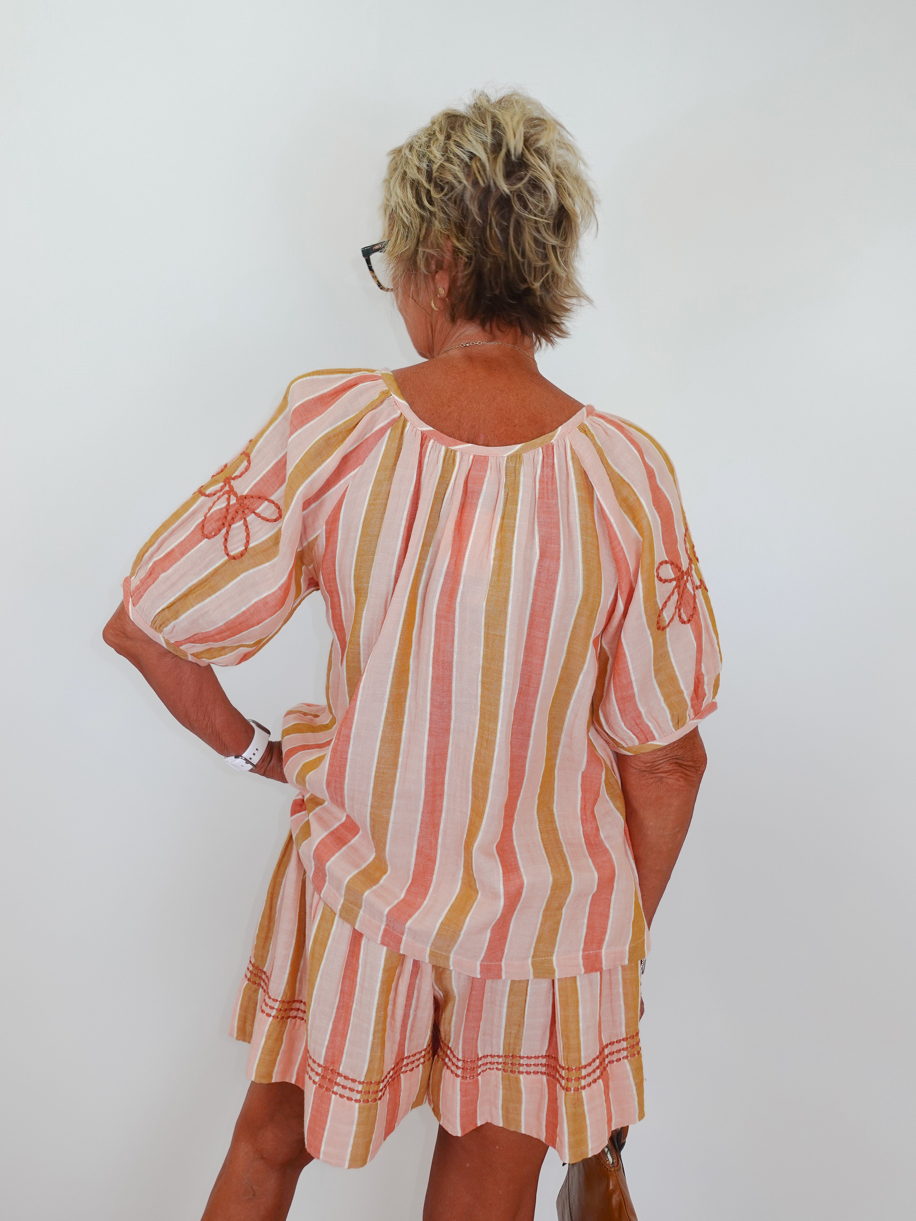 Woman wearing a striped dress with a white background