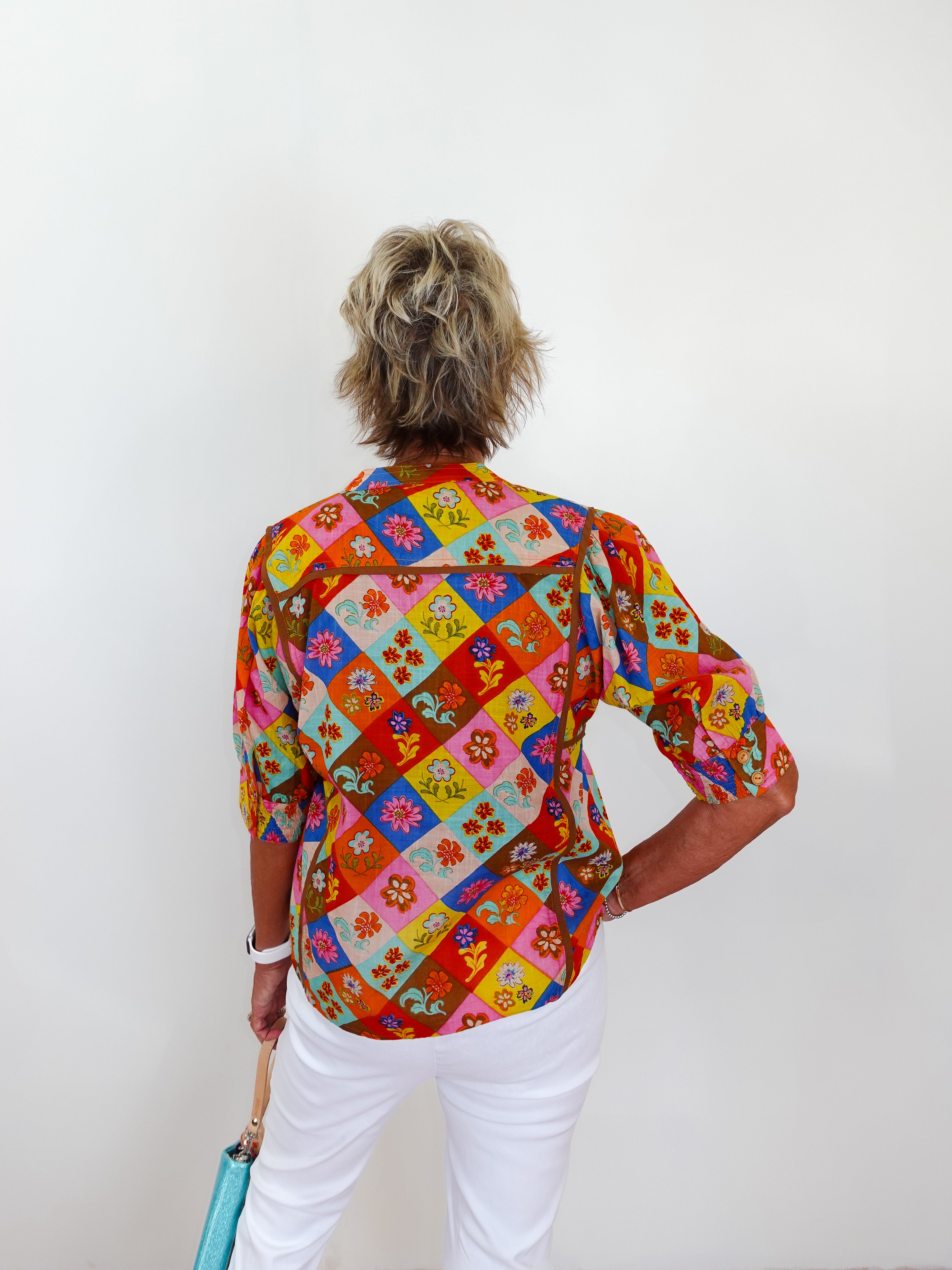Person wearing a colorful patterned shirt with a white background