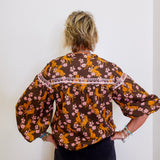 Person wearing a floral blouse with a white background