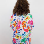Person wearing a colorful patterned shirt with a white background
