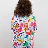 Person wearing a colorful patterned shirt with a white background