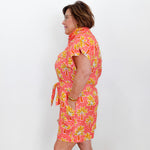 Woman wearing a pink floral dress against a white background