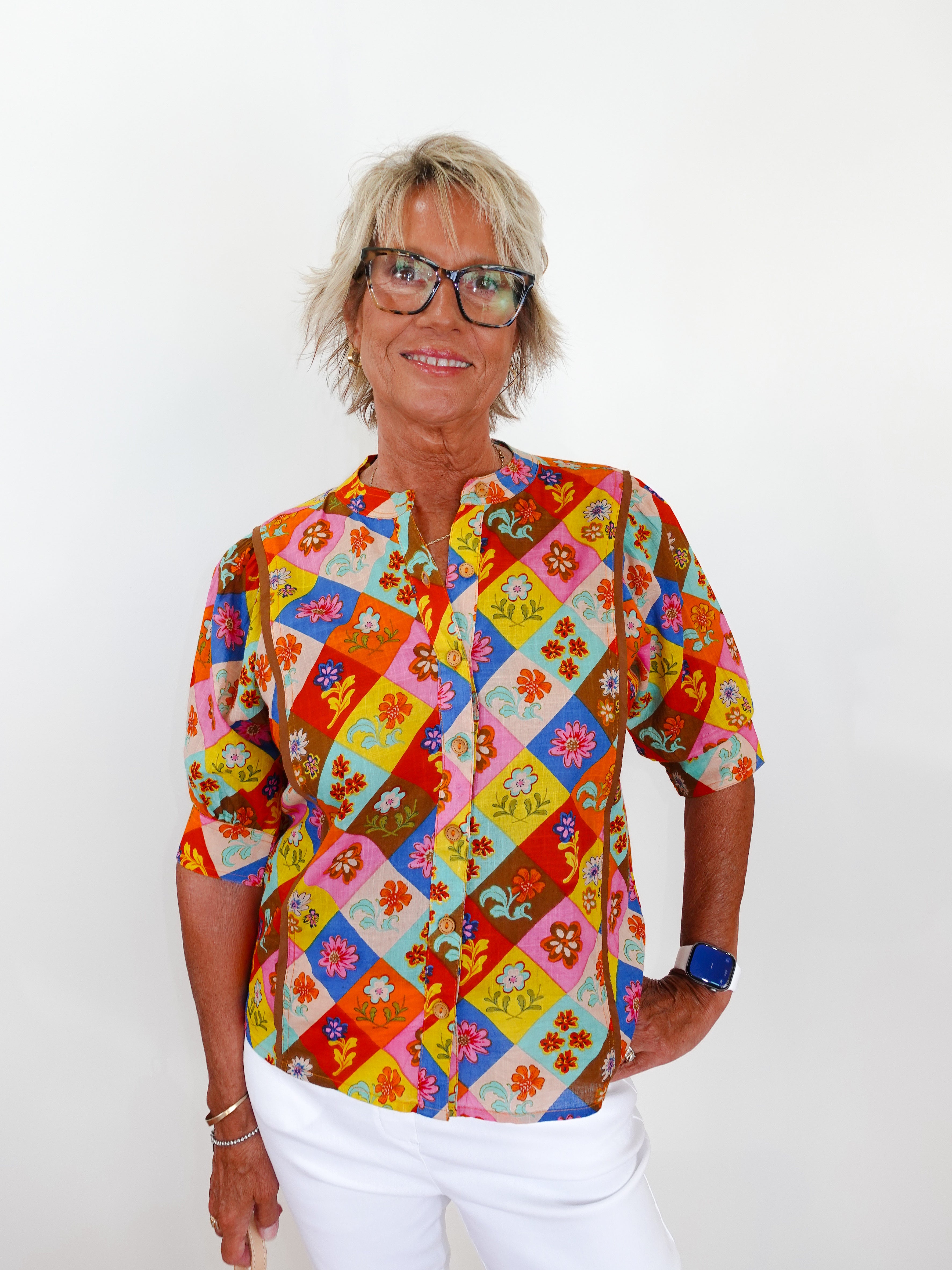 Person wearing a colorful patterned shirt with a white background