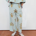 Person wearing a light blue outfit with floral patterns on a white background