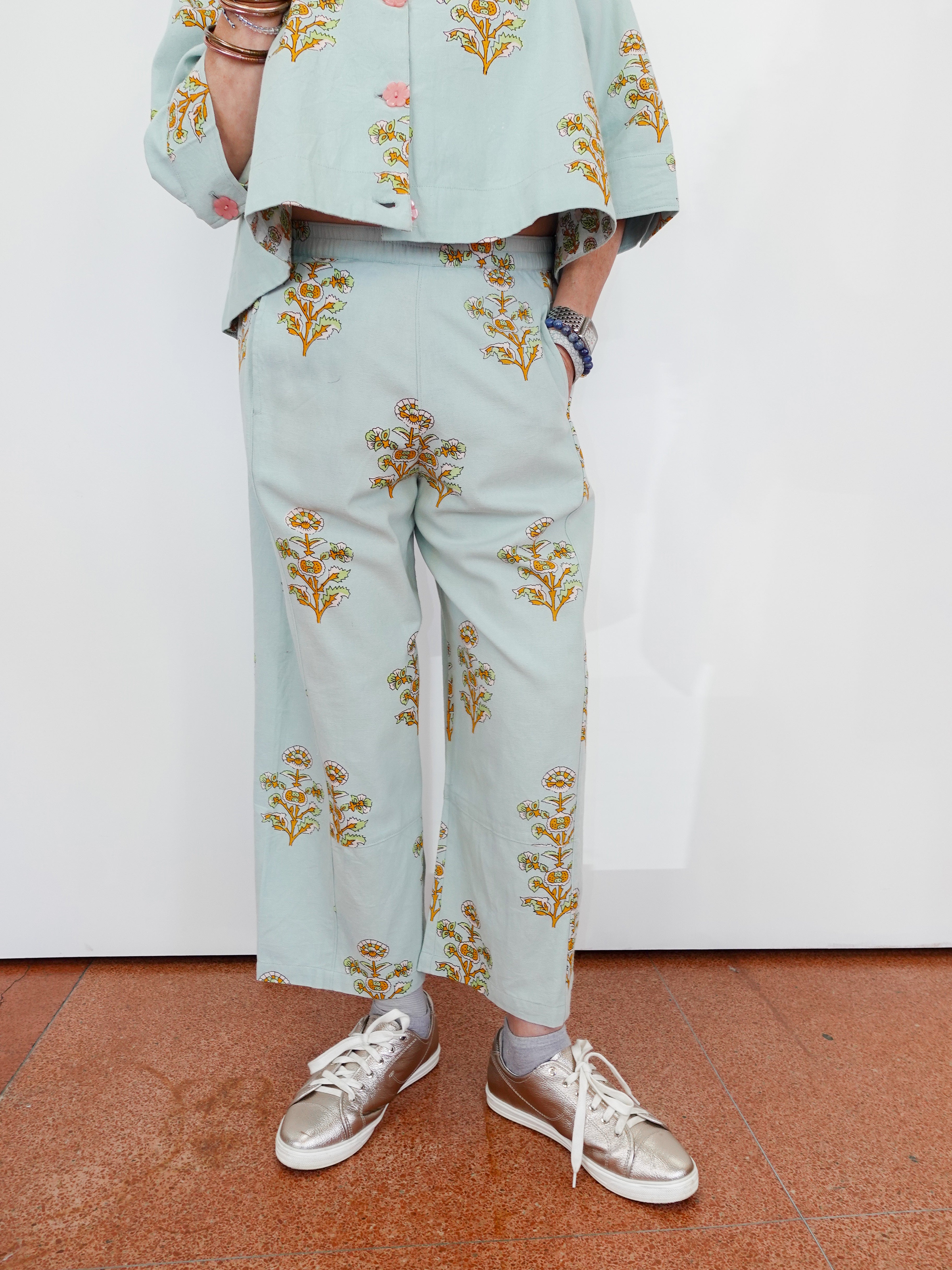 Person wearing a light blue outfit with floral patterns on a white background
